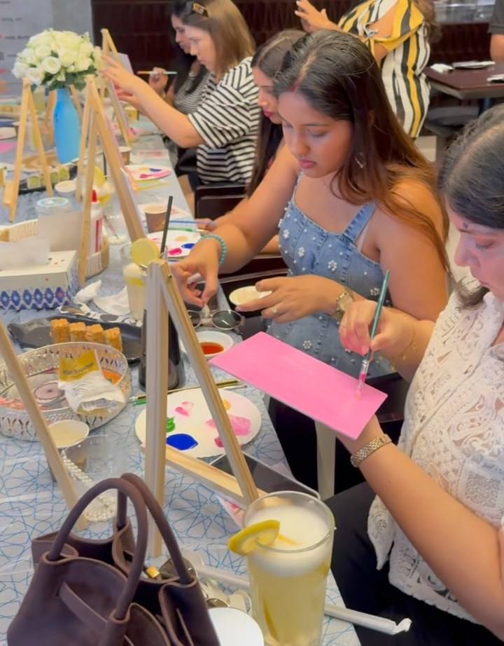 Guests painting pink canvases at an Art & Pause workshop