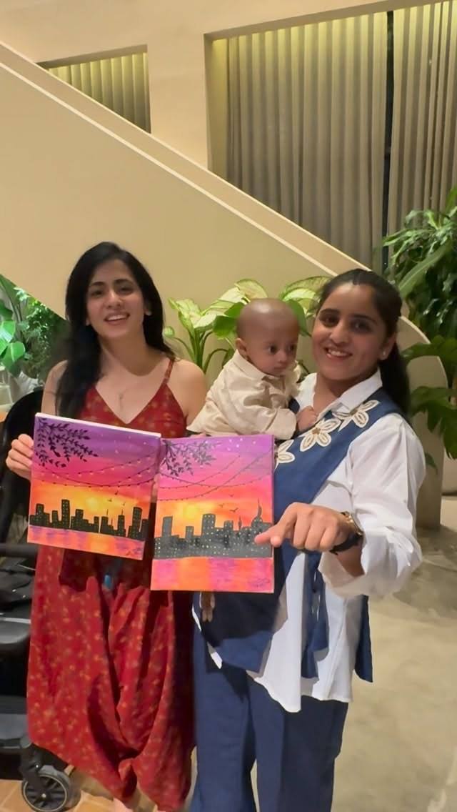 Guests showing their finished skyline paintings from an Art & Pause workshop