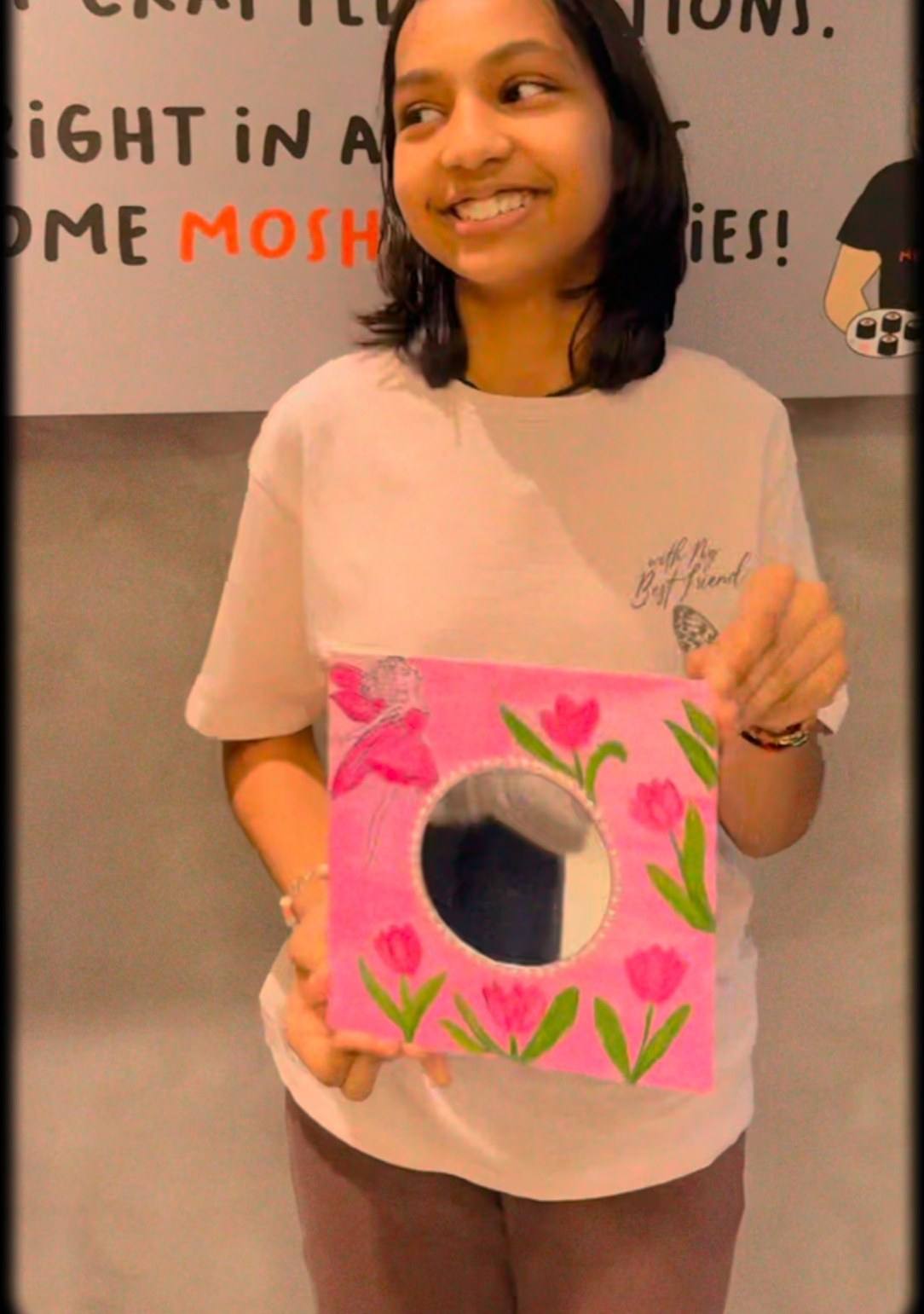A guest showing her finished tulip mirror painting from an Art & Pause workshop